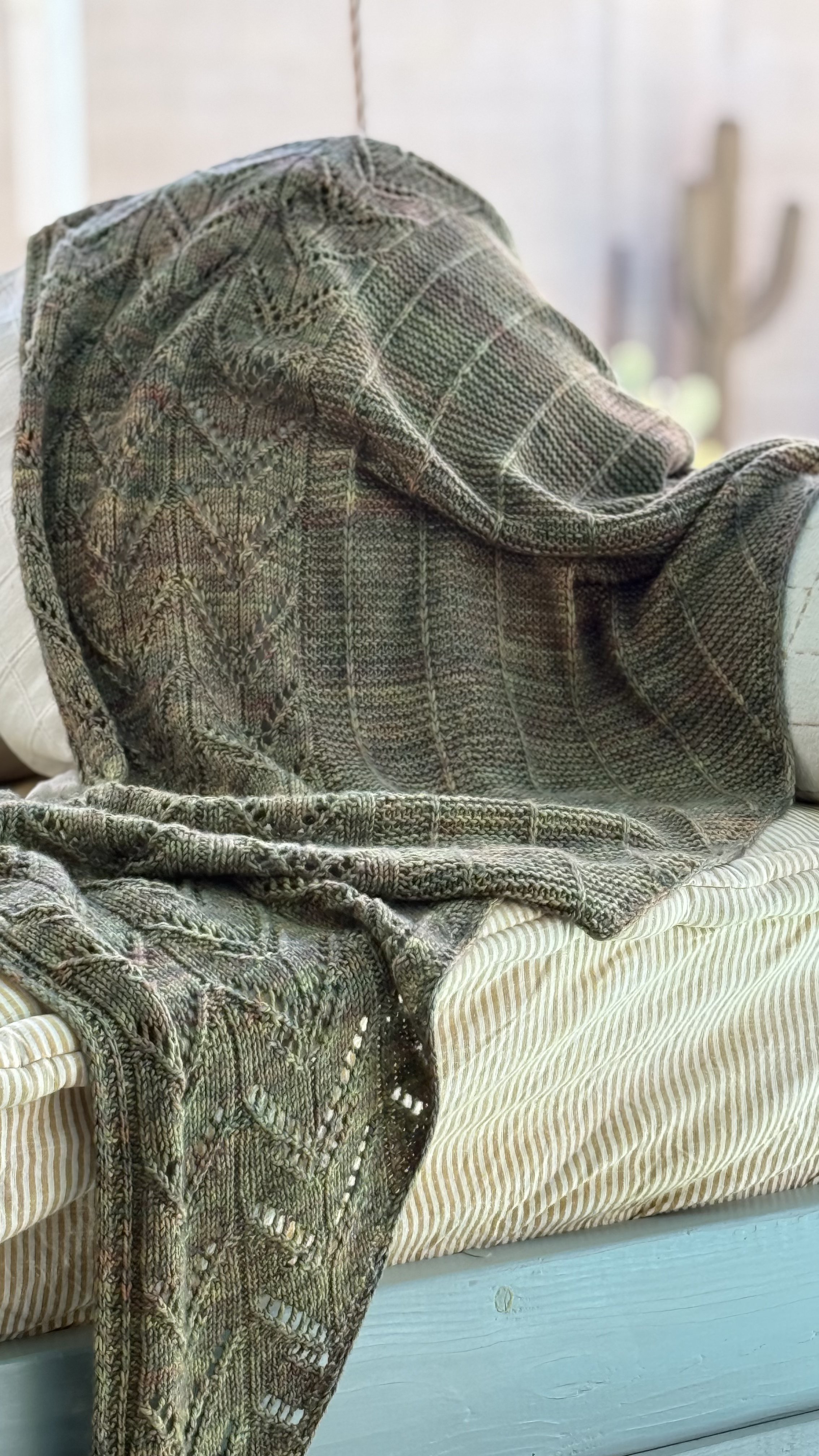 Kelcy's Garden shawl draped on a bench, showing full drape and lace border