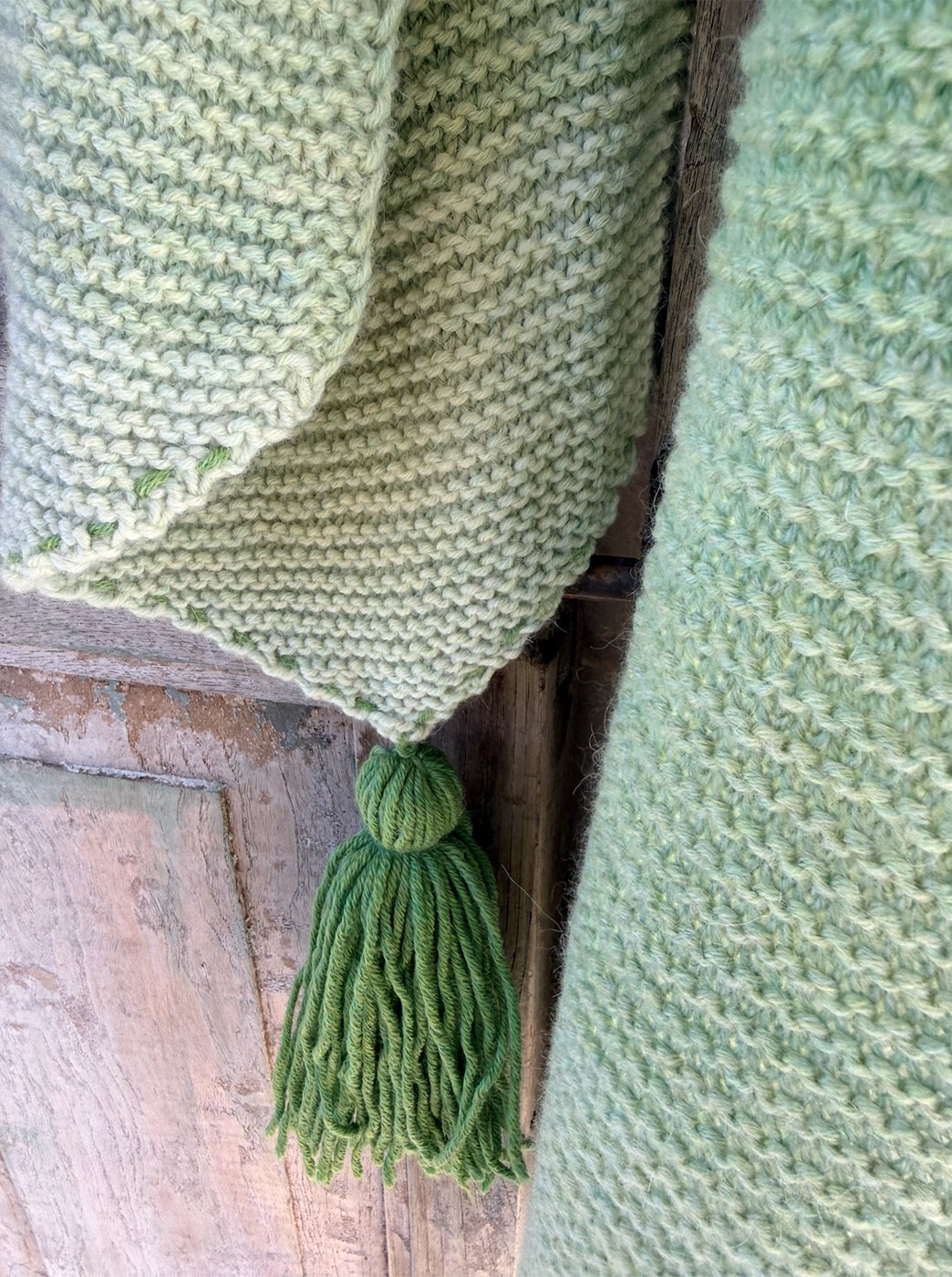 Pointed tip of the wrap with a chunky green tassel