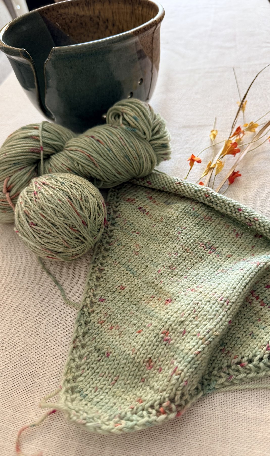 Sweetbriar Bandana in progress with yarn and dried flowers