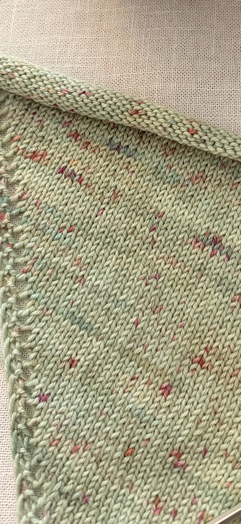 Close-up of the decorative eyelet edge and speckled yarn